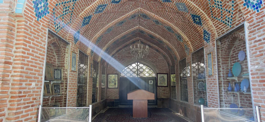 Brick-vaulted interior gallery with display cases at Yerevan Blue Mosque
