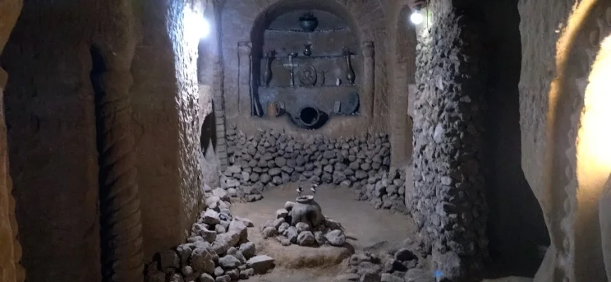 Narrow stone corridor leading toward the chapel-like chamber in Levon’s Underground