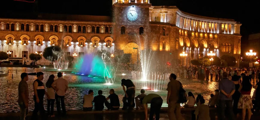 Singing fountains and illuminated Government House on Republic Square at night